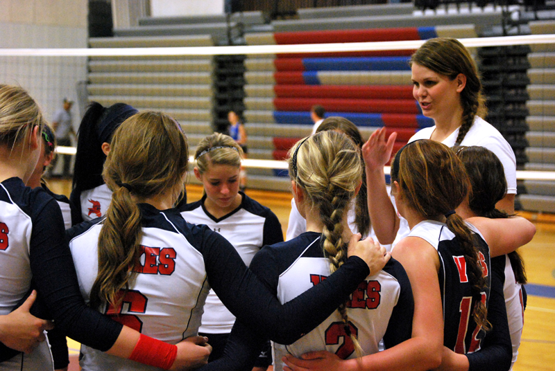 The volleyball team huddles up before their game against Washburn Rural on Senior Night.  Two girls, Tatiana Schafer and Erinn Steere, were honored for their years of service to the team.  (Photo by David Marshall)