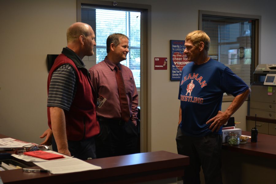 Wrestling coach Patrick Kelly and Principal Mike Monaghan meet with former state champ Ray Smith.