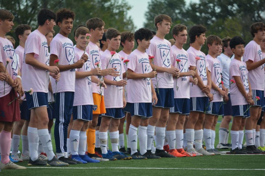The soccer team shows support for cancer awareness wearing pink shirts prior to the game.