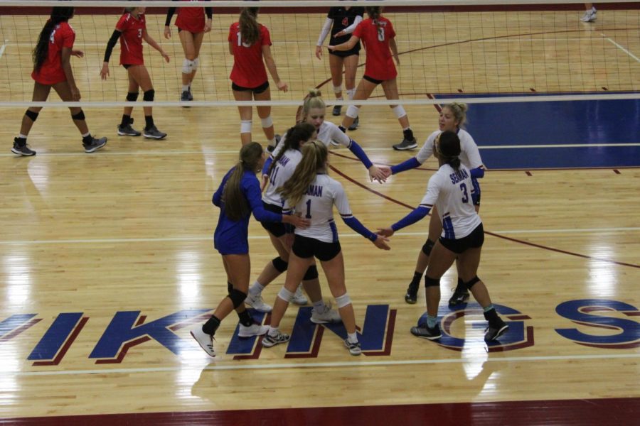 Varsity starters celebrate a kill at their home tournament in a match against Lansing. The Lady Vikes ended the tournament in second place.