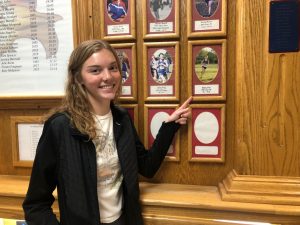Bethany Druse poses next to a picture of the record she broke this year. Druses name is posted three times in the SHS Cross Country Hall of Fame.