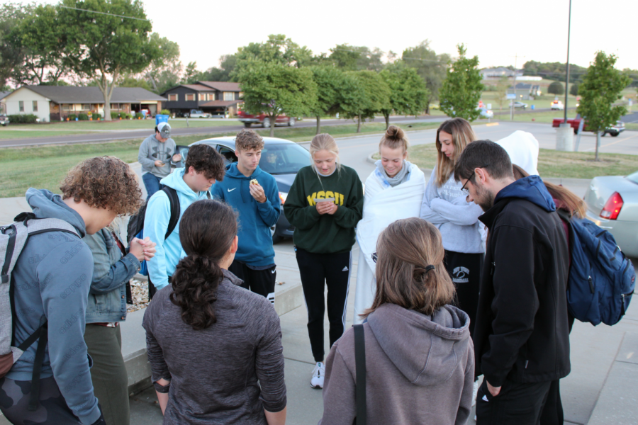 FCA, the Fellowship of Christian Athletes club, prays in front of the school by the American flag. Every year FCAs main event is the Flag Pole Pray, this year theyve had meetings every Friday morning in the choir room.