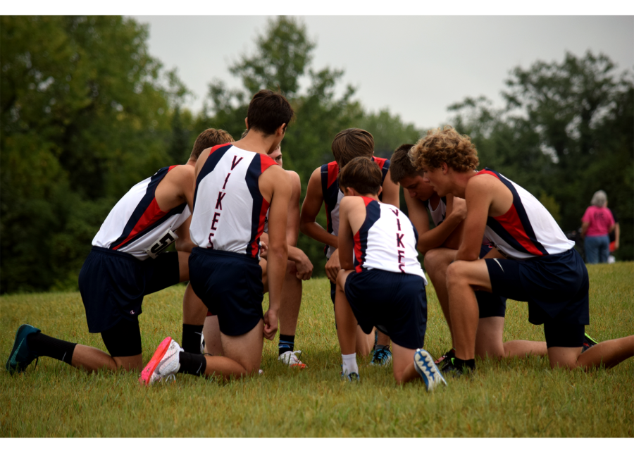 The boys varsity cross country team huddle together to have a pep talk before the September 3, 2021, meet at Manhattan.