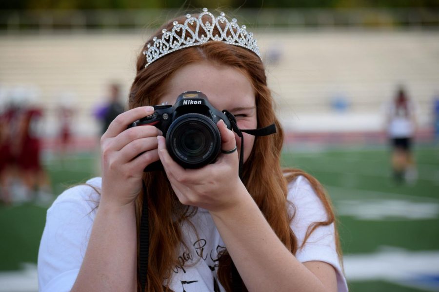 Senior and Ad Manager for the Clipper, Savanah Reeves, points her camera at photographer Madyson Hardesty during the September 17, 2021, Homecoming game against Junction City. Reeves later used photos she took from the game, along with photos others took of the assembly, bonfire, and crowning, to compile a photo slideshow of the 2021 Homecoming.