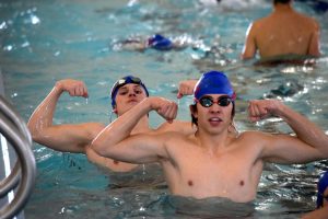 Senior Tim Biggs and junior Aiden Florence flex their muscles towards the camera while preparing for the city meet on Jan. 27, 2022, at Hummer Sports Park. The Vikings swim team placed second overall at the meet, as well as placing second at league, with both Biggs and Florence qualifying for state.