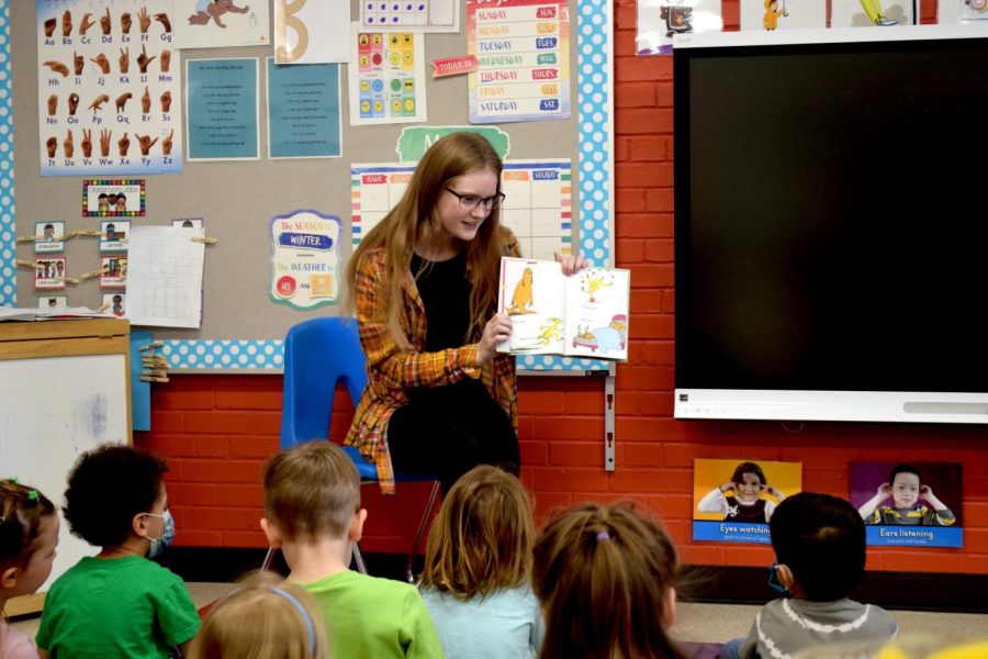 Senior Alyssa Boos reads a Dr. Seuss book to the preschoolers of the Mathes Early Learning Center on Mar. 2, 2022, for the Read Across America event that National Honors Society hosted. Read Across America aims to celebrate and encourage reading to children and young teens, and is organized by a variety of libraries, schools, and clubs across the United States.